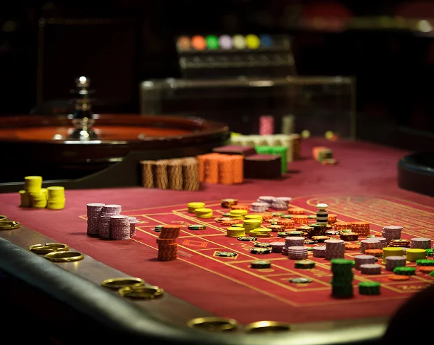 A roulette table is covered with colorful stacks of betting chips.
